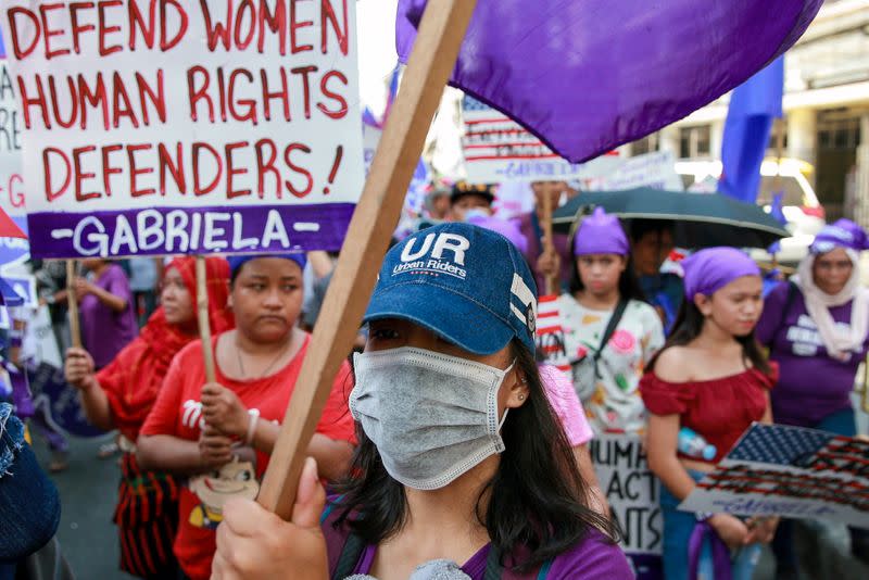 A women's rights activist wears a protective mask amid the coronavirus scare during a rally on International Women's Day in Manila