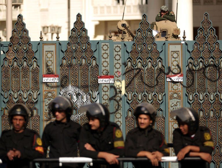 Riot police guard the gates of the presidential palace in Cairo. Egypt's powerful military has demanded the Islamist-led government and political foes start dialogue and warned it will not permit events to take a "disastrous" turn