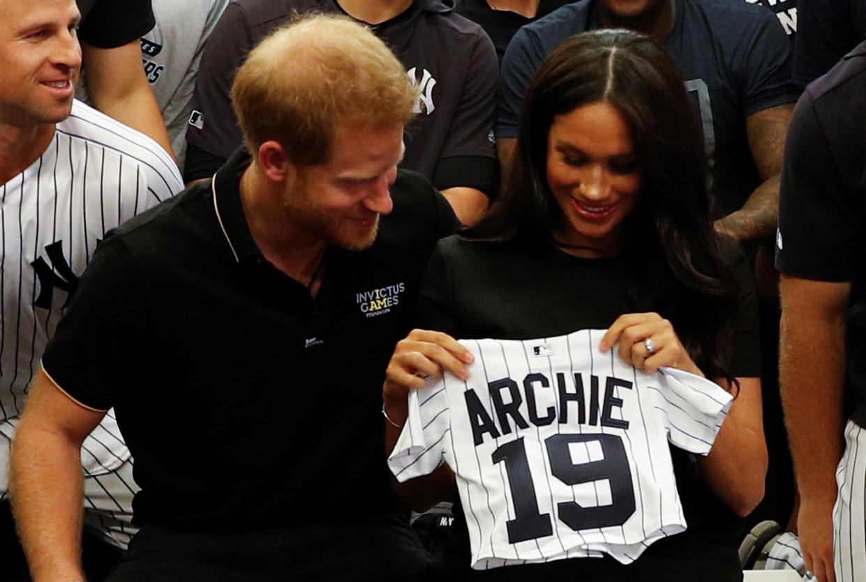 Britain's Prince Harry, Duke of Sussex, and his wife Meghan, Duchess of Sussex react as they are presented with gifts for her newborn son Archie, as they meet New York Yankees players ahead of their match against the Boston Red Sox at the London Stadium in Queen Elizabeth Olympic Park, east London on June 29, 2019, for the first of a two-game Baseball series in London. - As Major League Baseball prepares to make history in London, New York Yankees manager Aaron Boone and Boston Red Sox coach Alex Cora are united in their desire to make the ground-breaking trip memorable on and off the field. (Photo by PETER NICHOLLS / POOL / AFP)        (Photo credit should read PETER NICHOLLS/AFP/Getty Images)