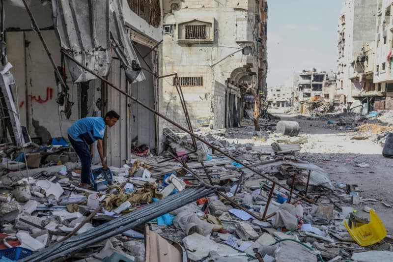 A Palestinian boy searches inside a destroyed home as he returns after the Israeli army withdrew from the Austrian neighbourhood during the violent battles between Israel and Hamas. Abed Rahim Khatib/dpa