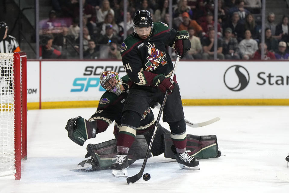 Arizona Coyotes defenseman Matt Dumba (24) makes a save in front of goaltender Karel Vejmelka during the second period of the team's NHL hockey game against the Carolina Hurricanes, Friday, Feb. 16, 2024, in Tempe, Ariz. (AP Photo/Rick Scuteri)