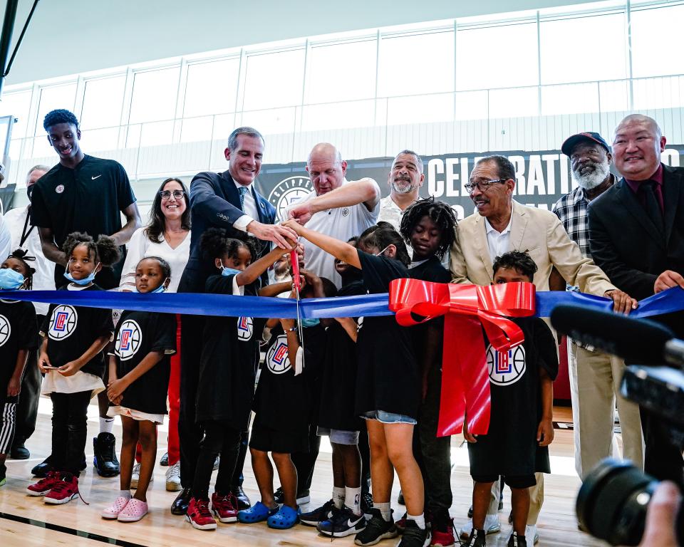 Los Angeles Mayor Eric Garcetti and Clippers owner Steve Ballmer (center) cut a blue ribbon to officially open the Clippers Community Courts at the Michelle and Barack Obama Sports Center in Los Angeles on June 28, 2022.