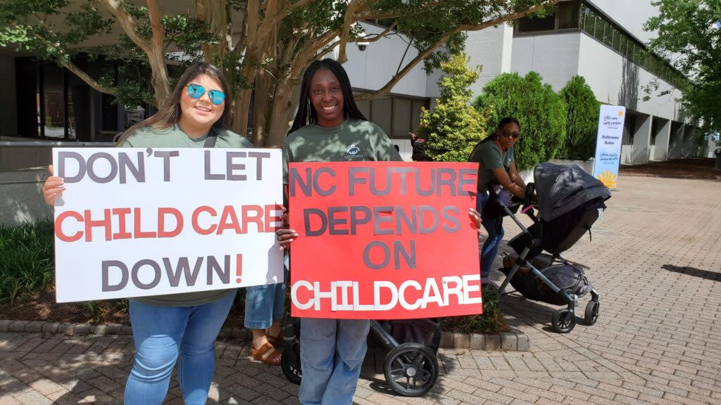 Childcare workers hold signs calling for legislative action