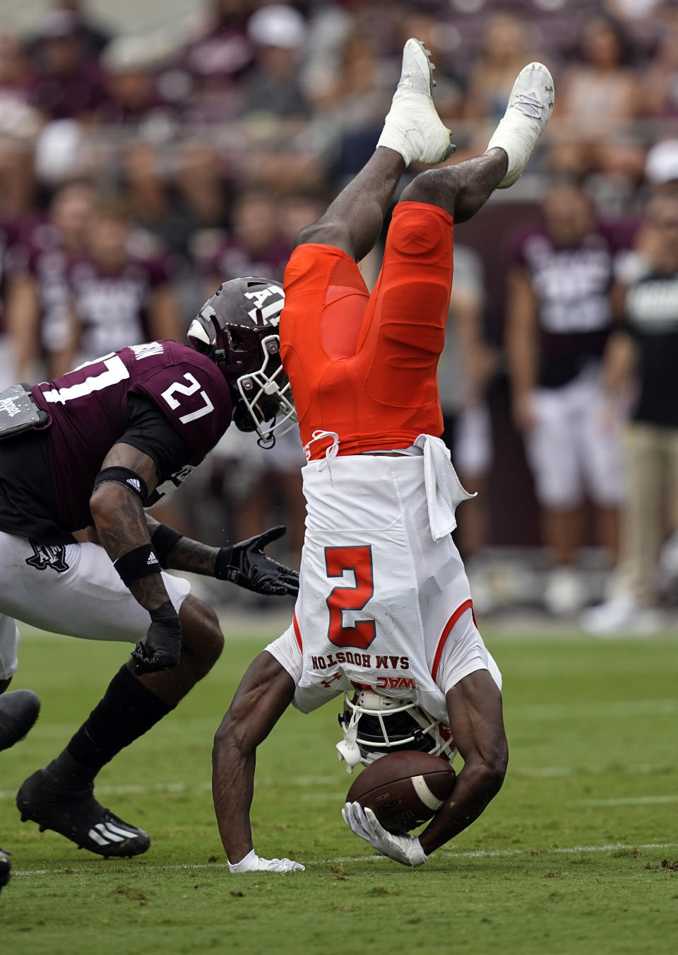 Sam Houston State wide receiver Ife Adeyi (2) flips upside down as Texas A&M defensive back Antonio Johnson (27) defends during the first half of an NCAA college football game Saturday, Sept. 3, 2022, in College Station, Texas. (AP Photo/David J. Phillip)