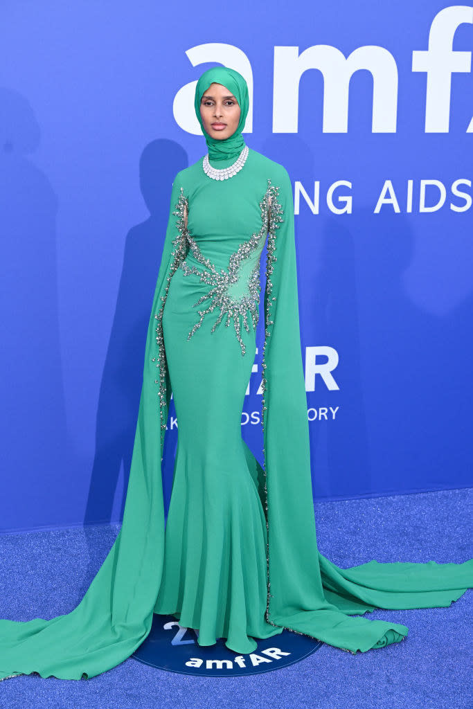 Rawdah is wearing long gown with extremely long sleeves that is decorated with jewels around the bodice