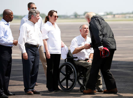 U.S. President Donald Trump greets Texas Governor Greg Abbott after arriving at Ellington Field to meet with flood survivors and volunteers who assisted in relief efforts in the aftermath of Hurricane Harvey, in Houston, Texas, U.S., September 2, 2017. REUTERS/Kevin Lamarque