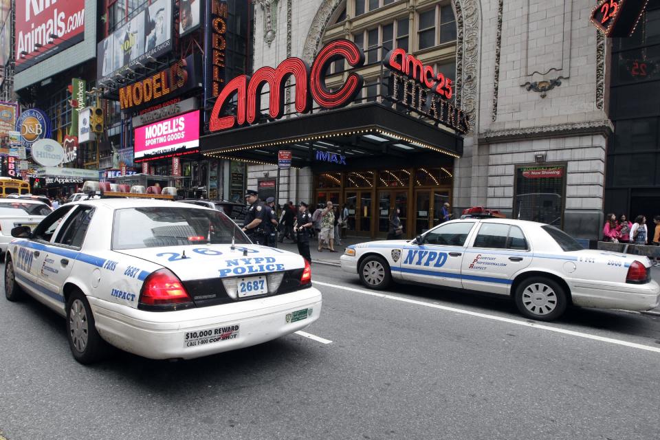 Police officers are seen outside a movie theater screening “The Dark Knight Rises,” Friday, July 20, 2012 in New York. A gunman in a gas mask barged into a crowded Denver-area theater during a midnight premiere of the Batman movie on Friday, hurled a gas canister and then opened fire, killing 12 people and injuring at least 50 others in one of the deadliest mass shootings in recent U.S. history. NYPD commissioner Ray Kelly said the department was providing the extra security at theaters "as a precaution against copycats and to raise the comfort levels among movie patrons." (AP Photo/Mary Altaffer)