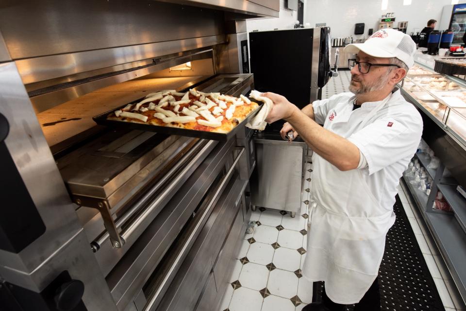 Amico Scarpitti, a pastry chef at Alto Bakery & Caffè in Warminster, places a Roman-style pizza into an oven, on Tuesday, January 23, 2024.