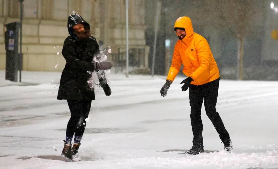 Frank Snyder and his girlfriend Jenna Eckel play in the snow in downtown Raleigh, N.C., Friday evening Jan. 21, 2022.