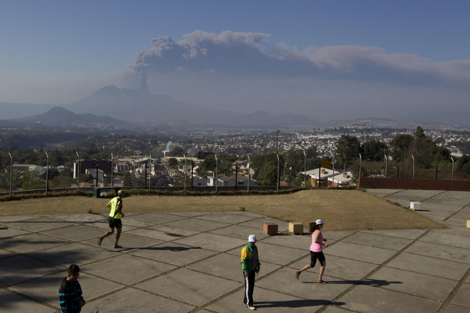 Residents exercise as a column of ash rises from the Pacaya volcano in Villa Nueva, Guatemala, Sunday, March 2, 2014. Guatemala authorities say the Pacaya volcano near Guatemala City has shot plumes of ash and vapor 2.3 miles (3.7 kilometers) high, while spewing glowing-hot rock. The eruption early Sunday is the latest round of activity at the scenic volcano located just 30 miles (50 kms) south of Guatemala City. (AP Photo/Moises Castillo)