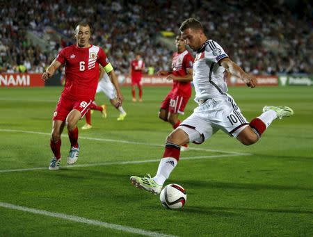 Germany's Lukas Podolski (R) kicks the ball next to Gibraltar's Roy Chipolina during their Euro 2016 qualifying soccer match at Algarve stadium in Faro, Portugal, June 13, 2015. REUTERS/Rafael Marchante