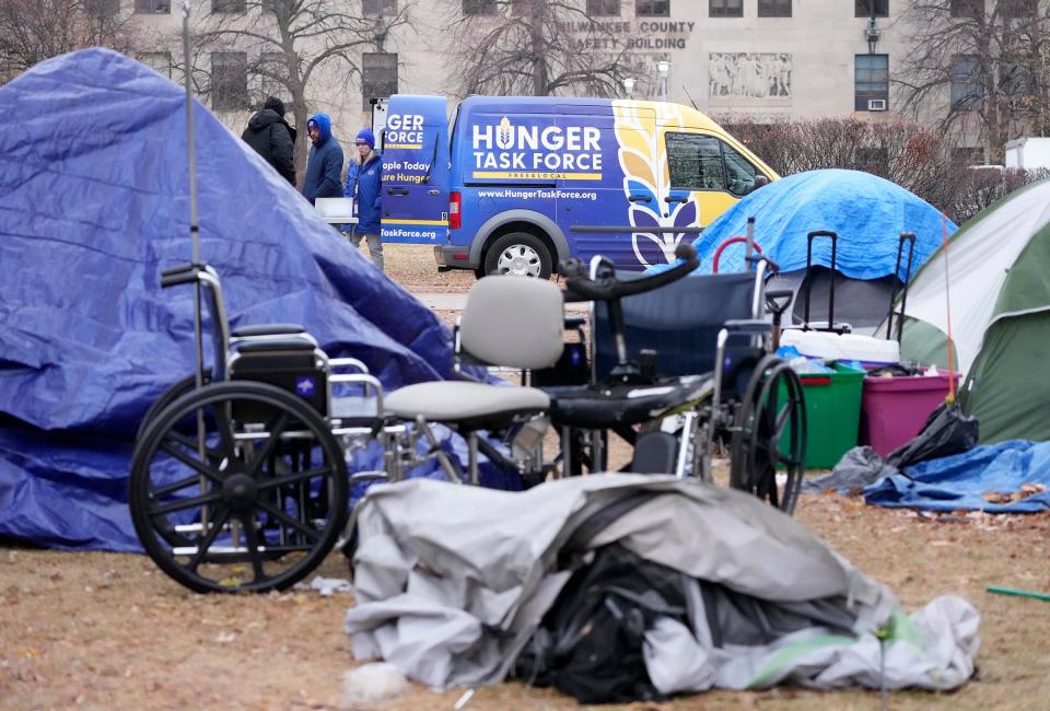 A Hunger Task Force vehicle hands out food where people have set up tents at MacArthur Park near 9th and Wells streets in Milwaukee earlier this month.