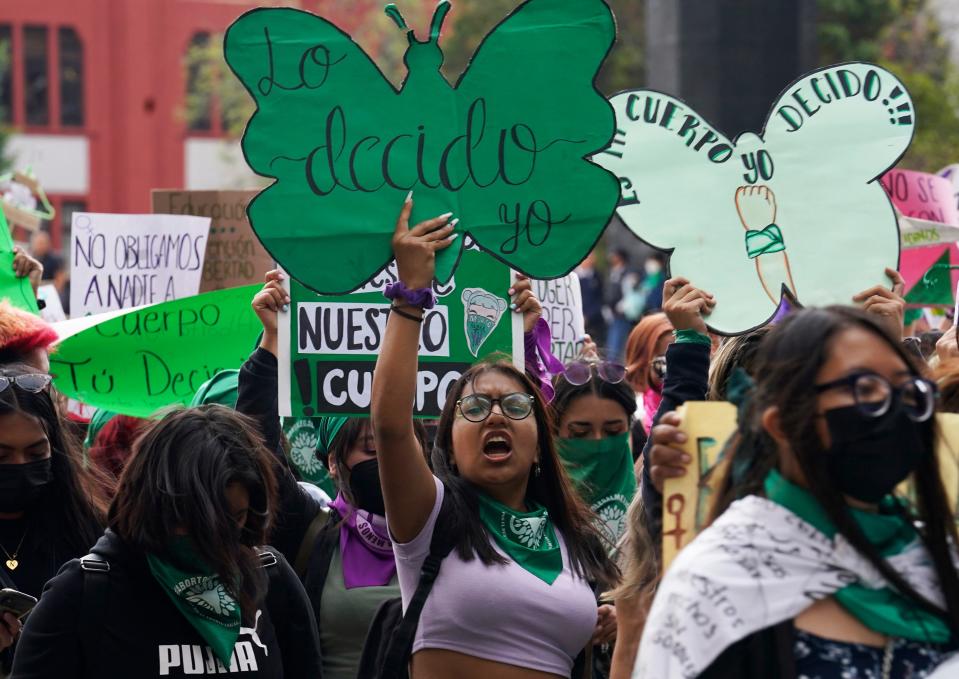 A woman holds up a sign with a message that reads in Spanish; "I will decide" as she joins a march in Mexico City, Sept. 28, 2022.