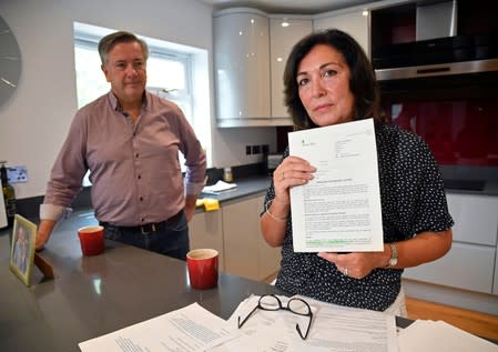 Anna Amato holds documentation and correspondence with The Home Office, with her husband Connell at her home in Bristol