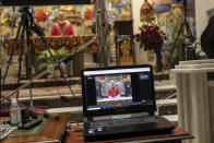 Catholic priests live video stream the Palm Sunday mass inside the Jesus de Medinaceli church in Madrid, Spain, Sunday, April 5, 2020. Pilgrims were not allowed to attend the mass due to social distancing guidelines during the coronavirus outbreak. The new coronavirus causes mild or moderate symptoms for most people, but for some, especially older adults and people with existing health problems, it can cause more severe illness or death. (AP Photo/Bernat Armangue)