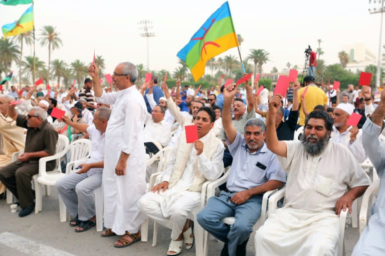 Libyans raise red cards during a protest against the national unity government proposed by United Nations envoy Bernardino Leon on October 9, 2015 in Tripoli's central Martyrs Square