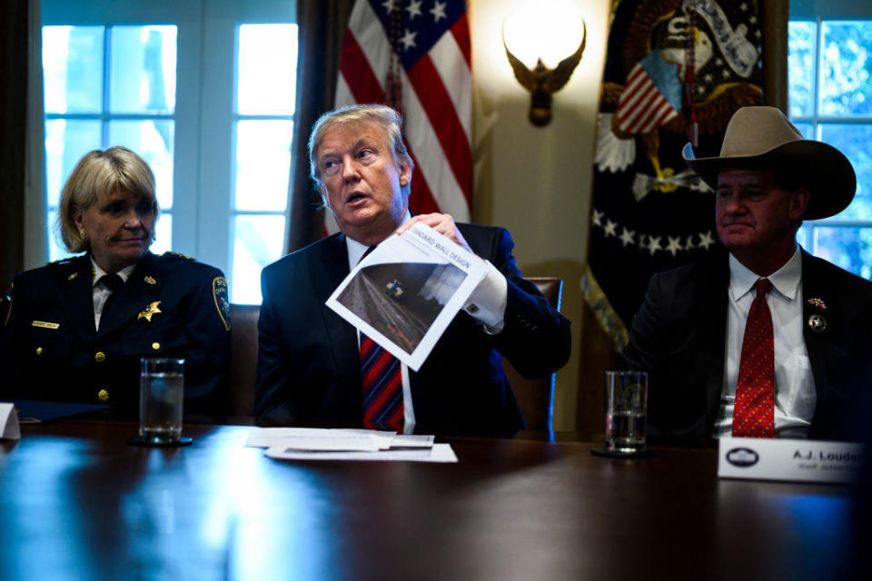 President Donald Trump holds up a photo of a 