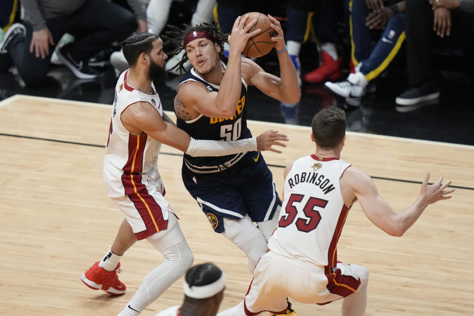 Miami Heat forward Caleb Martin (16) and forward Duncan Robinson (55) defend Denver Nuggets forward Aaron Gordon (50) during the first half of Game 4 of the basketball NBA Finals, Friday, June 9, 2023, in Miami. (AP Photo/Lynne Sladky)