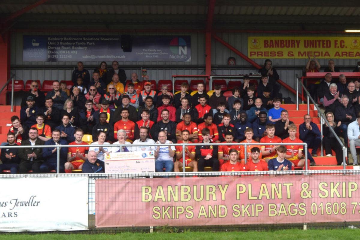 Clive Wright (front) of the Banbury United Community Lottery presents the cheque to members of the Keep the Horton General campaign <i>(Image: Banbury United)</i>