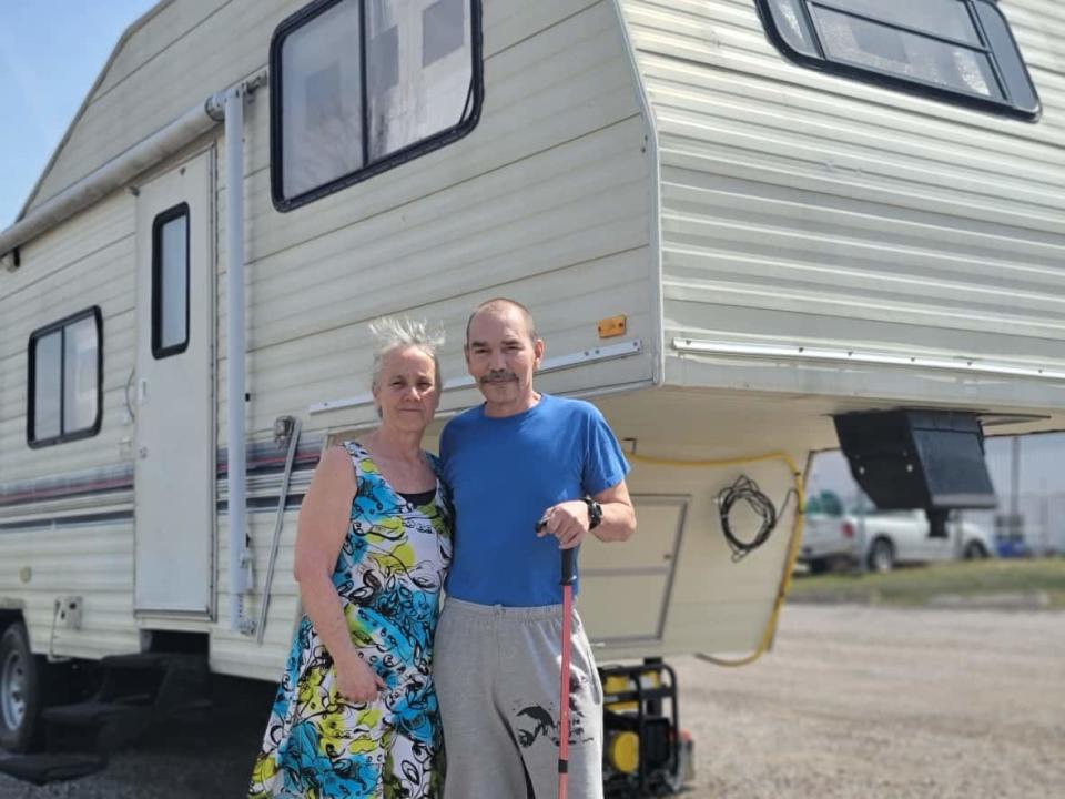 Kim Springer and her husband Dan, left to right, and their grandson went from housed to living in a 30-year-old camper in an east London, Ont., parking lot in the span of nine months. (Alessio Donnini/CBC News - image credit)