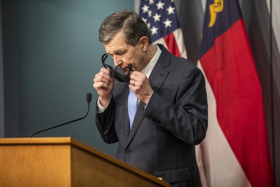 North Carolina Gov. Roy Cooper takes off his mask before speaking during a briefing on North Carolina's coronavirus pandemic response Monday, Nov. 23, 2020 at the NC Emergency Operations Center in Raleigh. (Travis Long/The News & Observer via AP)