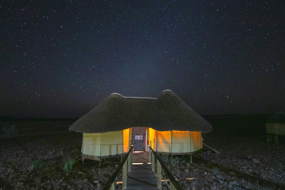 Glowing lights from a bush chalet at Sossusvlei desert camp, as the Namibian skies fill with stars. (Photo: Gordon Donovan/Yahoo News)