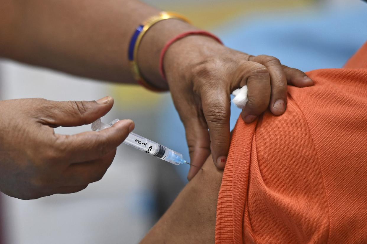 A medical worker inoculates a man with the Covaxin Covid-19 coronavirus vaccine, at a health center in New Delhi on April 29, 2021.