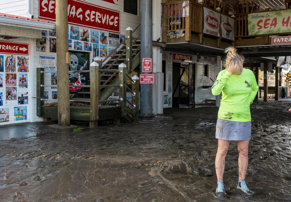 Sea Hag owner Daniell Norwood stands at her business that was damaged after Hurricane Helene hit the area on September 27, 2024 in Steinhatchee, Florida.