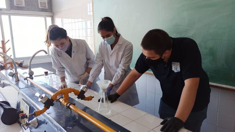 Agustín Mangüello, Victoria Wesner y Karla Buscamante, creadores de un filtro para microplásticos del lavarropas, en el laboratorio del colegio donde hicieron el desarrollo