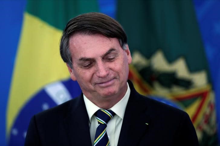 Brazil's President Bolsonaro smiles at a media statement in Brasilia