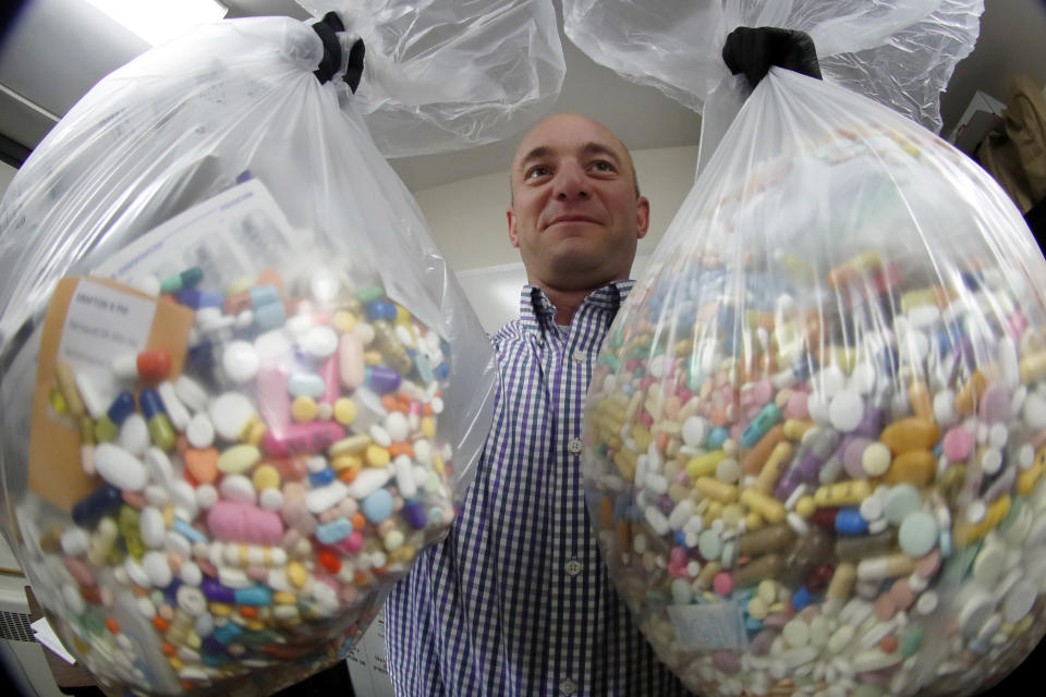 CORRECTS STATE TO OHIO NOT PENNSYLVANIA - Narcotics detective Ben Hill, with the Barberton Police Department, shows two bags of medications that are are stored in their headquarters and slated for destruction, Wednesday, Sept. 11, 2019, in Barberton, Ohio. Attorneys representing some 2,000 local governments said Wednesday they have agreed to a tentative settlement with OxyContin maker Purdue Pharma over the toll of the nation's opioid crisis. (AP Photo/Keith Srakocic)
