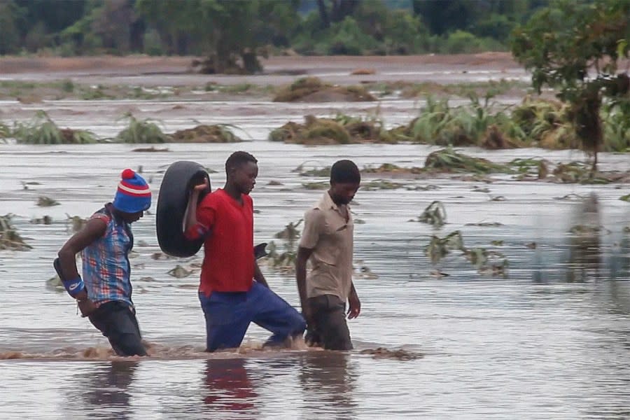 People walk on a road swept by flooding waters in Chikwawa, Malawi, Tuesday Jan. 25, 2022. (AP Photo, File)