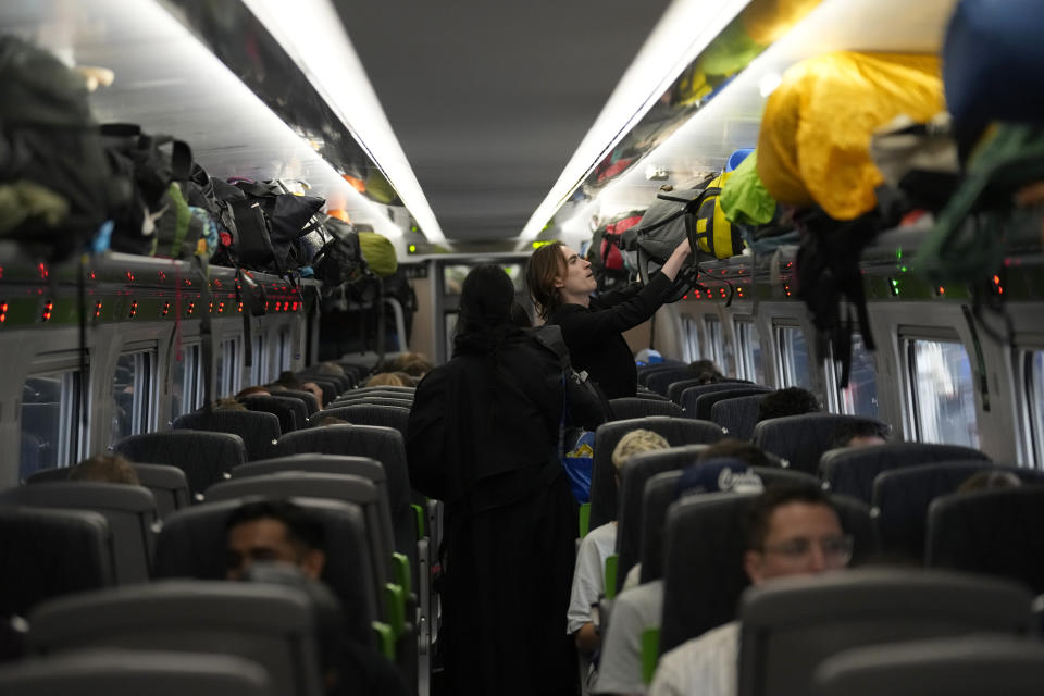 The camping bags of passengers going to the Glastonbury music festival fill the overheads on a train before it left Paddington railway station, in London, during a railway workers strike, Thursday, June 23, 2022. Millions of people in Britain faced disruption Thursday as railway staff staged their second national walkout this week. (AP Photo/Matt Dunham)