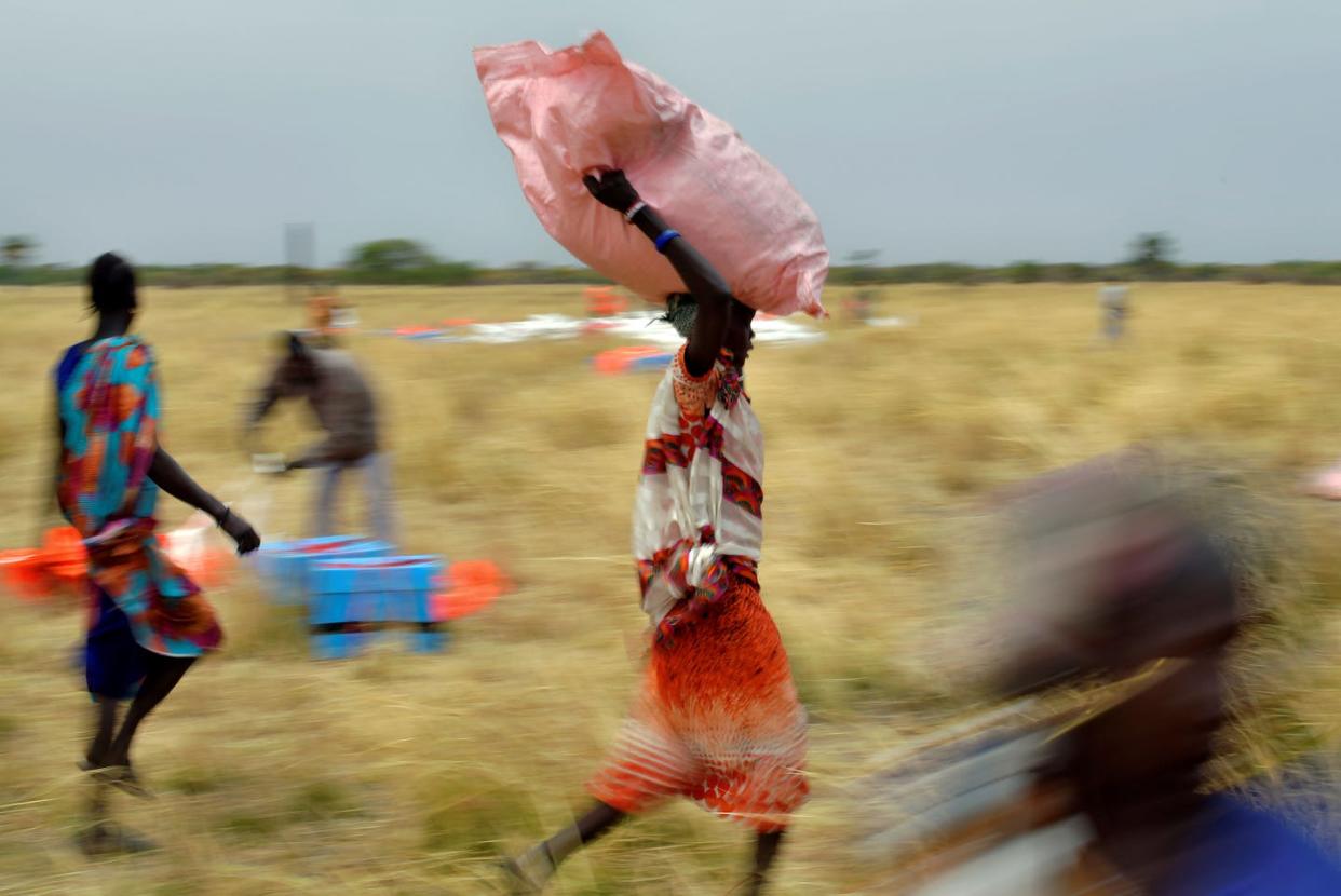<span class="caption">Villagers collect World Food Programme aid dropped from a plane Feb. 6 in South Sudan.</span> <span class="attribution"><a class="link " href="https://www.gettyimages.com/detail/news-photo/villagers-collect-food-aid-dropped-from-a-plane-in-gunny-news-photo/1206126143?adppopup=true" rel="nofollow noopener" target="_blank" data-ylk="slk:Tony Karumba/AFP via Getty Images;elm:context_link;itc:0;sec:content-canvas">Tony Karumba/AFP via Getty Images</a></span>