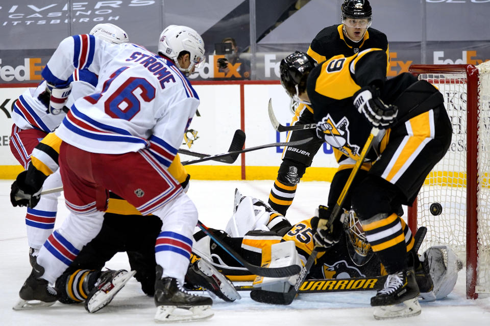 New York Rangers' Ryan Strome (16) lifts a rebound over Pittsburgh Penguins goaltender Tristan Jarry (35) for a goal during the second period of an NHL hockey game in Pittsburgh, Sunday, Jan. 24, 2021. (AP Photo/Gene J. Puskar)