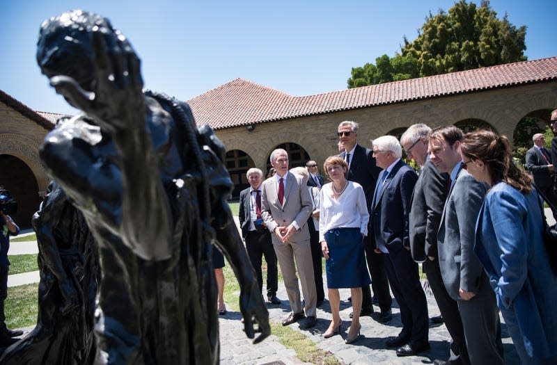 19 June 2018, USA, California: German President Frank-Walter Steinmeier (4-R) and his wife Elke Buedenbender (6-R) walking on the grounds of Stanford University with the President of the University, Marc Tessier-Lavigne (2-L), Bernd Girod (4-L), Professor of Electrical Engineering, and the delegation and looking at a cast of the Rodin sculpture “The Burghers of Calais”. 