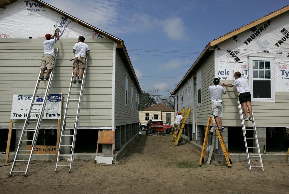 Volunteer construction workers with Habitat for Humanity build new homes August 23, 2006 in Upper Ninth Ward of New Orleans, Louisiana, as part of The Musicians' Village.