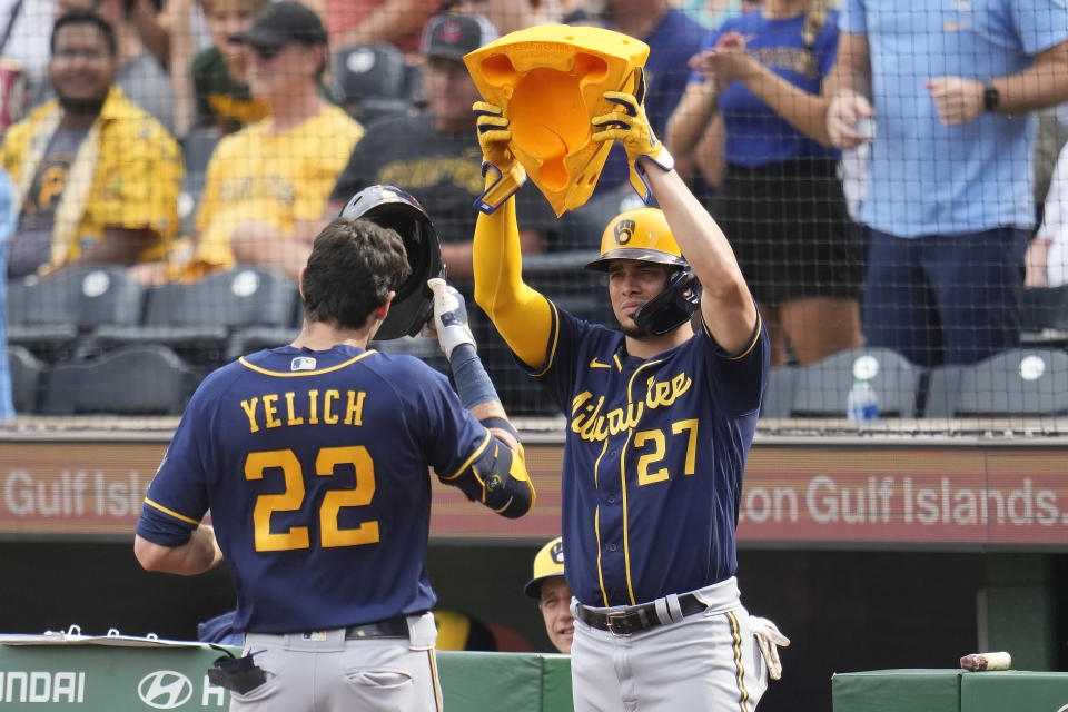 Milwaukee Brewers' Christian Yelich (22) is greeted at the dugout steps by Willy Adames (27) after hitting a three-run home run off Pittsburgh Pirates starting pitcher Johan Oviedo during the second inning of a baseball game in Pittsburgh, Saturday, July 1, 2023. (AP Photo/Gene J. Puskar)