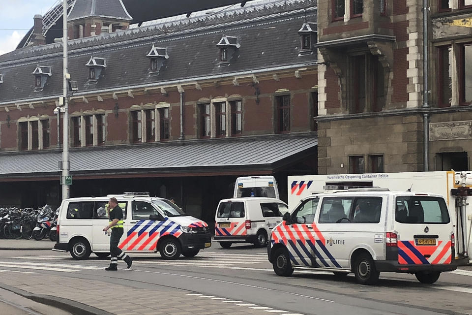 Dutch police officers near the scene of a stabbing attack near the central daily station in Amsterdam, the Netherlands, Friday Aug. 31, 2018. Police the Dutch capital shot and wounded a suspect Friday following a stabbing at the central railway station. Amsterdam police said in a series of tweets that two people were injured in the stabbing and the suspect was then shot by officers. (AP Photo/Alex Furtula)