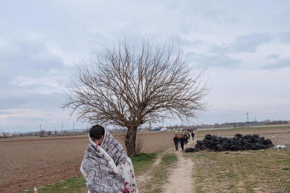 Migrants walk through a field toward the Turkey-Greece border. | Emin Ozmen—Magnum Photos for TIME