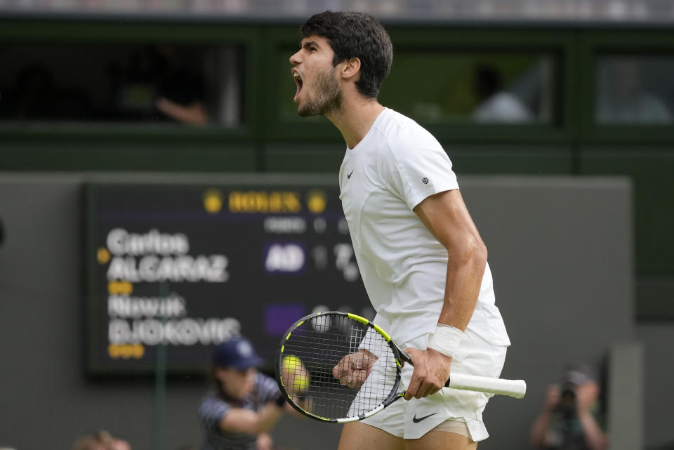 Carlos Alcaraz grita tras ganar un punto ante Novak Djokovic durante la final masculina de Wimbledon, el domingo 16 de julio de 2023, en Londres. (AP Foto/Kirsty Wigglesworth)