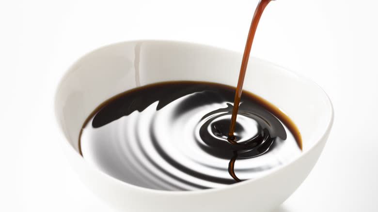 Worcestershire sauce pouring into white dish