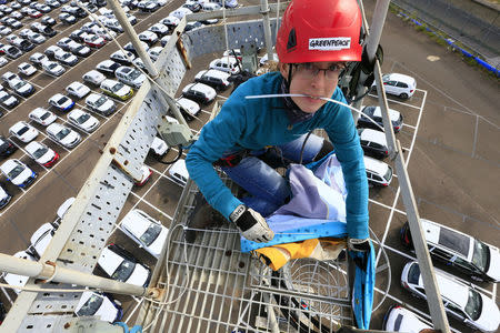 A Greenpeace volunteer is seen after gaining access to the vehicle park during an action directed at Volkswagen diesel vehicles at the port of Sheerness, Britain, September 21, 2017. Jiri Rezac/Greenpeace handout via REUTERS