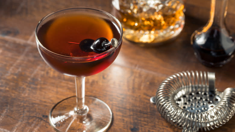 a manhattan cocktail with cherry garnish