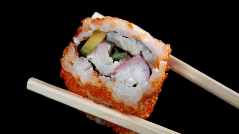 Crab sushi roll in chopsticks