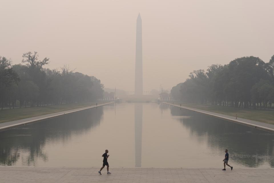 FILE - With the Washington Monument in the background and with a thick layer of smoke people run at the National Mall, June 8, 2023, in Washington. Thick, smoky air from Canadian wildfires made for days of misery in New York City and across the U.S. Northeast this week. But for much of the rest of the world, breathing dangerously polluted air is an inescapable fact of life — and death. (AP Photo/Jose Luis Magana, File)