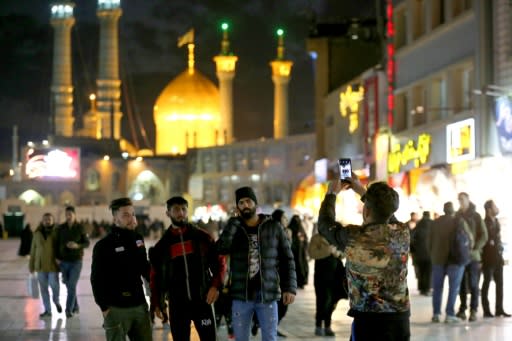 Visitors take a picture near Massoumeh shrine in Iran's holy city of Qom