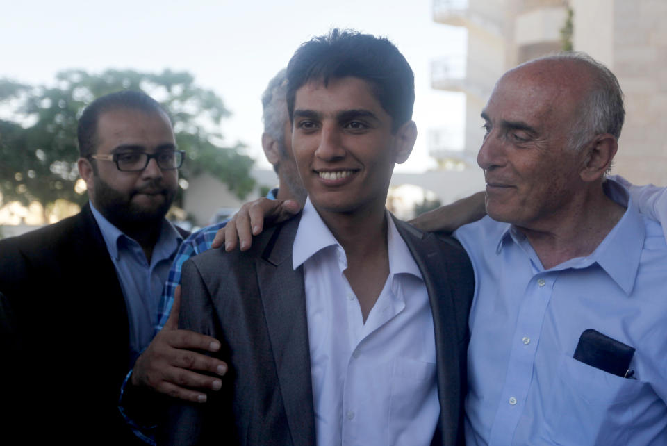 Arab Idol winner Palestinian Mohammed Assaf, center, is welcomed by Muneb Al-Masri, a Palestinain businessman, right, upon his arrival to Rafah crossing point on the border between Egypt and the southern Gaza Strip, Tuesday, June 25, 2013. Huge crowds of Gazans gave a gleeful welcome Tuesday to the first Palestinian winner of the Arab Idol talent contest, thronging the territory's border crossing with Egypt and the singer's home in hopes of embracing him, but internal politics surfaced quickly. Assaf’s victory in the popular contest Saturday sparked huge celebrations in the West Bank and Gaza, giving Palestinians a sense of pride. (AP Photo/ Hatem Moussa)