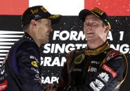 Red Bull Formula One driver Sebastian Vettel of Germany (L) celebrates on the podium with Lotus F1 Formula One driver Kimi Raikkonen of Finland after the Singapore F1 Grand Prix at the Marina Bay street circuit in Singapore September 22, 2013. REUTERS/Pablo Sanchez (SINGAPORE - Tags: SPORT MOTORSPORT F1)