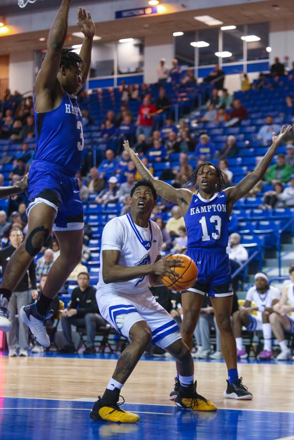 Delaware's Jalun Trent moves to the basket between Hampton's Kyrese Mullen (left) and Trey Thomas in the second half of Delaware's 80-53 win to start league play, Thursday, Jan. 4, 2024 at the Bob Carpenter Center.